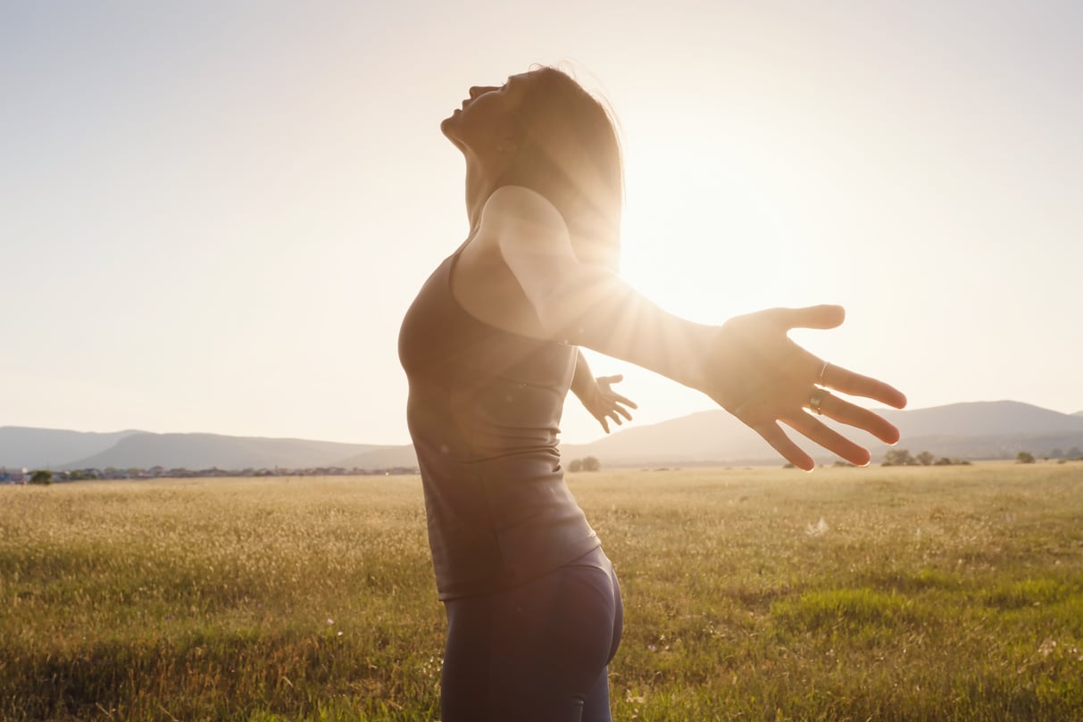 Young girl spreading hands with joy and inspiration facing t